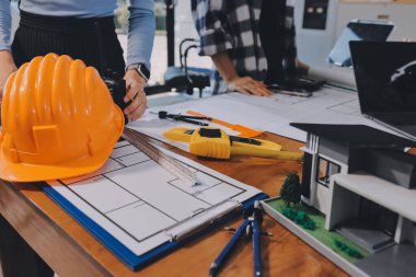 Modellik ve mühendislik araçları, inşaat konsepti ve çalışma sahasındaki proje ortağı ile çalışma planı toplantısı üzerine çalışan mühendis inşaat ve yapı kavramı.