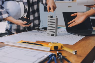 Modellik ve mühendislik araçları, inşaat konsepti ve çalışma sahasındaki proje ortağı ile çalışma planı toplantısı üzerine çalışan mühendis inşaat ve yapı kavramı.