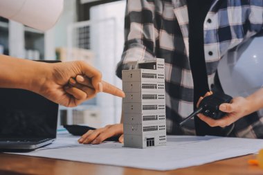 Modellik ve mühendislik araçları, inşaat konsepti ve çalışma sahasındaki proje ortağı ile çalışma planı toplantısı üzerine çalışan mühendis inşaat ve yapı kavramı.