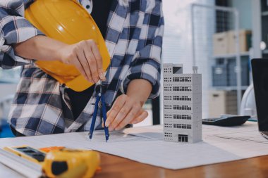 Modellik ve mühendislik araçları, inşaat konsepti ve çalışma sahasındaki proje ortağı ile çalışma planı toplantısı üzerine çalışan mühendis inşaat ve yapı kavramı.