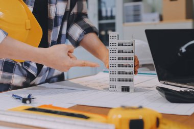 Modellik ve mühendislik araçları, inşaat konsepti ve çalışma sahasındaki proje ortağı ile çalışma planı toplantısı üzerine çalışan mühendis inşaat ve yapı kavramı.