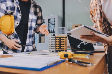 Modellik ve mühendislik araçları, inşaat konsepti ve çalışma sahasındaki proje ortağı ile çalışma planı toplantısı üzerine çalışan mühendis inşaat ve yapı kavramı.