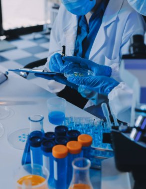 Araştırma ya da geliştirme için laboratuardaki insanlarla işbirliği, tablet ya da bilim. Tıbbi araştırma ve planlama için klinik deneyde bilim adamlarıyla buluşlar, teknolojiler ve mikroskop