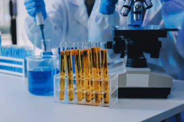 Araştırma ya da geliştirme için laboratuardaki insanlarla işbirliği, tablet ya da bilim. Tıbbi araştırma ve planlama için klinik deneyde bilim adamlarıyla buluşlar, teknolojiler ve mikroskop