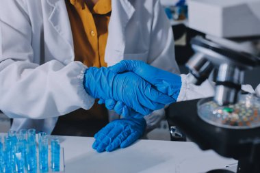 Araştırma ya da geliştirme için laboratuardaki insanlarla işbirliği, tablet ya da bilim. Tıbbi araştırma ve planlama için klinik deneyde bilim adamlarıyla buluşlar, teknolojiler ve mikroskop