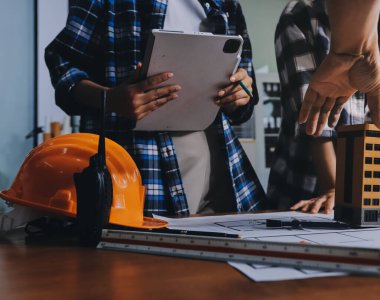 Modellik ve mühendislik araçları, inşaat konsepti ve çalışma sahasındaki proje ortağı ile çalışma planı toplantısı üzerine çalışan mühendis inşaat ve yapı kavramı.