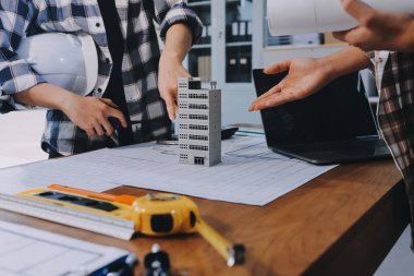 Modellik ve mühendislik araçları, inşaat konsepti ve çalışma sahasındaki proje ortağı ile çalışma planı toplantısı üzerine çalışan mühendis inşaat ve yapı kavramı.