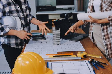 Modellik ve mühendislik araçları, inşaat konsepti ve çalışma sahasındaki proje ortağı ile çalışma planı toplantısı üzerine çalışan mühendis inşaat ve yapı kavramı.
