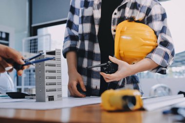 Modellik ve mühendislik araçları, inşaat konsepti ve çalışma sahasındaki proje ortağı ile çalışma planı toplantısı üzerine çalışan mühendis inşaat ve yapı kavramı.