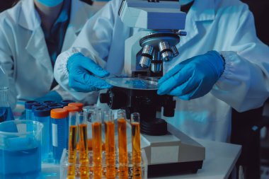 Araştırma ya da geliştirme için laboratuardaki insanlarla işbirliği, tablet ya da bilim. Tıbbi araştırma ve planlama için klinik deneyde bilim adamlarıyla buluşlar, teknolojiler ve mikroskop