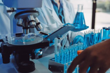 Araştırma ya da geliştirme için laboratuardaki insanlarla işbirliği, tablet ya da bilim. Tıbbi araştırma ve planlama için klinik deneyde bilim adamlarıyla buluşlar, teknolojiler ve mikroskop