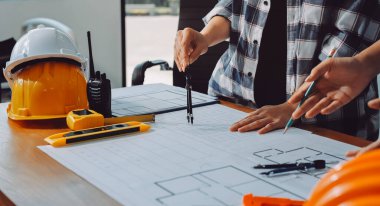 Modellik ve mühendislik araçları, inşaat konsepti ve çalışma sahasındaki proje ortağı ile çalışma planı toplantısı üzerine çalışan mühendis inşaat ve yapı kavramı.