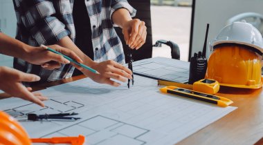 Modellik ve mühendislik araçları, inşaat konsepti ve çalışma sahasındaki proje ortağı ile çalışma planı toplantısı üzerine çalışan mühendis inşaat ve yapı kavramı.