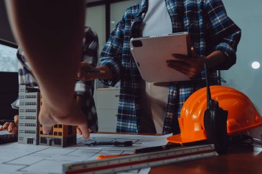 Modellik ve mühendislik araçları, inşaat konsepti ve çalışma sahasındaki proje ortağı ile çalışma planı toplantısı üzerine çalışan mühendis inşaat ve yapı kavramı.