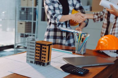 Modellik ve mühendislik araçları, inşaat konsepti ve çalışma sahasındaki proje ortağı ile çalışma planı toplantısı üzerine çalışan mühendis inşaat ve yapı kavramı.