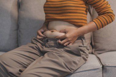 Şişman karnına dokunup sıkarken çekilmiş bir fotoğraf..