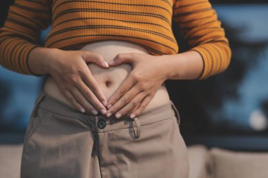 Şişman karnına dokunup sıkarken çekilmiş bir fotoğraf..