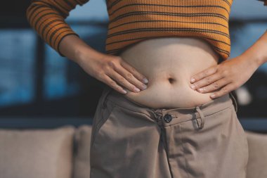 Şişman karnına dokunup sıkarken çekilmiş bir fotoğraf..