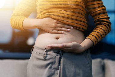 Şişman karnına dokunup sıkarken çekilmiş bir fotoğraf..