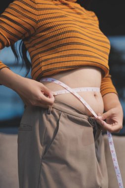 Şişman karnına dokunup sıkarken çekilmiş bir fotoğraf..