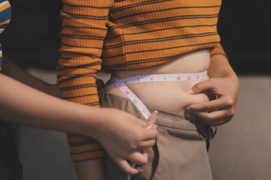 Şişman karnına dokunup sıkarken çekilmiş bir fotoğraf..