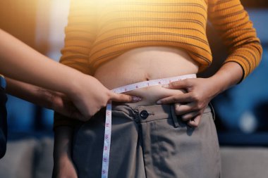 Şişman karnına dokunup sıkarken çekilmiş bir fotoğraf..