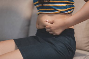 Şişman karnına dokunup sıkarken çekilmiş bir fotoğraf..