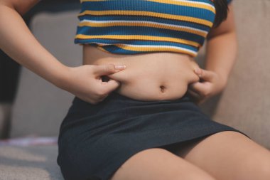 Şişman karnına dokunup sıkarken çekilmiş bir fotoğraf..