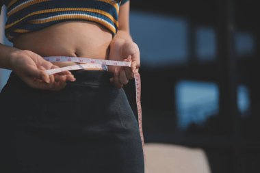 Şişman karnına dokunup sıkarken çekilmiş bir fotoğraf..