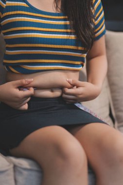 Şişman karnına dokunup sıkarken çekilmiş bir fotoğraf..