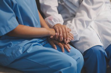 Görüntüleri kapatın, doktor hastaya tavsiye vermek ve hastalıkla mücadeleyi teşvik etmek için el ele tutuşuyor ve yaşlı hastalara ve sağlık hizmetleri konseptine destek oluyor..