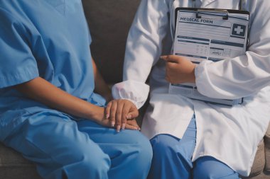 Görüntüleri kapatın, doktor hastaya tavsiye vermek ve hastalıkla mücadeleyi teşvik etmek için el ele tutuşuyor ve yaşlı hastalara ve sağlık hizmetleri konseptine destek oluyor..