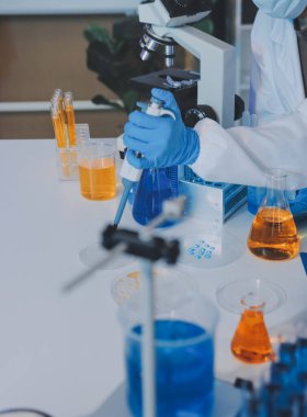 Araştırma ya da geliştirme için laboratuardaki insanlarla işbirliği, tablet ya da bilim. Tıbbi araştırma ve planlama için klinik deneyde bilim adamlarıyla buluşlar, teknolojiler ve mikroskop