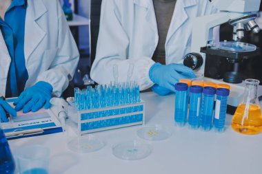 Araştırma ya da geliştirme için laboratuardaki insanlarla işbirliği, tablet ya da bilim. Tıbbi araştırma ve planlama için klinik deneyde bilim adamlarıyla buluşlar, teknolojiler ve mikroskop