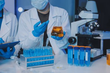 Araştırma ya da geliştirme için laboratuardaki insanlarla işbirliği, tablet ya da bilim. Tıbbi araştırma ve planlama için klinik deneyde bilim adamlarıyla buluşlar, teknolojiler ve mikroskop