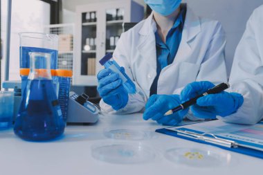 Araştırma ya da geliştirme için laboratuardaki insanlarla işbirliği, tablet ya da bilim. Tıbbi araştırma ve planlama için klinik deneyde bilim adamlarıyla buluşlar, teknolojiler ve mikroskop