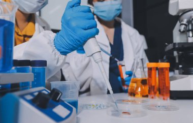 Araştırma ya da geliştirme için laboratuardaki insanlarla işbirliği, tablet ya da bilim. Tıbbi araştırma ve planlama için klinik deneyde bilim adamlarıyla buluşlar, teknolojiler ve mikroskop