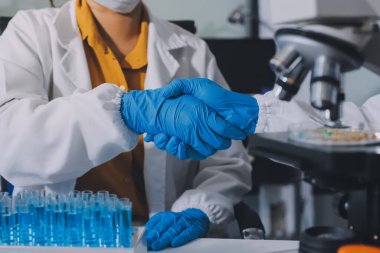 Araştırma ya da geliştirme için laboratuardaki insanlarla işbirliği, tablet ya da bilim. Tıbbi araştırma ve planlama için klinik deneyde bilim adamlarıyla buluşlar, teknolojiler ve mikroskop