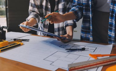 Modellik ve mühendislik araçları, inşaat konsepti ve çalışma sahasındaki proje ortağı ile çalışma planı toplantısı üzerine çalışan mühendis inşaat ve yapı kavramı.