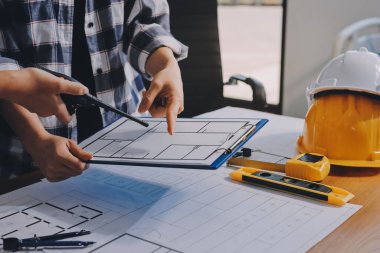 Modellik ve mühendislik araçları, inşaat konsepti ve çalışma sahasındaki proje ortağı ile çalışma planı toplantısı üzerine çalışan mühendis inşaat ve yapı kavramı.