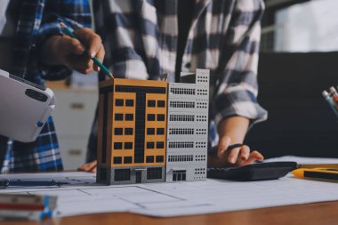 Modellik ve mühendislik araçları, inşaat konsepti ve çalışma sahasındaki proje ortağı ile çalışma planı toplantısı üzerine çalışan mühendis inşaat ve yapı kavramı.