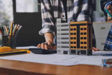 Modellik ve mühendislik araçları, inşaat konsepti ve çalışma sahasındaki proje ortağı ile çalışma planı toplantısı üzerine çalışan mühendis inşaat ve yapı kavramı.