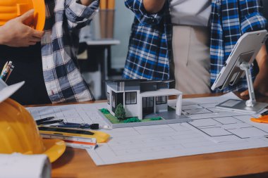 Modellik ve mühendislik araçları, inşaat konsepti ve çalışma sahasındaki proje ortağı ile çalışma planı toplantısı üzerine çalışan mühendis inşaat ve yapı kavramı.