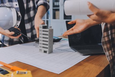 Modellik ve mühendislik araçları, inşaat konsepti ve çalışma sahasındaki proje ortağı ile çalışma planı toplantısı üzerine çalışan mühendis inşaat ve yapı kavramı.