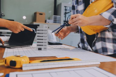 Modellik ve mühendislik araçları, inşaat konsepti ve çalışma sahasındaki proje ortağı ile çalışma planı toplantısı üzerine çalışan mühendis inşaat ve yapı kavramı.
