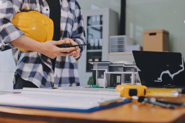 Modellik ve mühendislik araçları, inşaat konsepti ve çalışma sahasındaki proje ortağı ile çalışma planı toplantısı üzerine çalışan mühendis inşaat ve yapı kavramı.