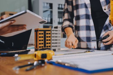 Modellik ve mühendislik araçları, inşaat konsepti ve çalışma sahasındaki proje ortağı ile çalışma planı toplantısı üzerine çalışan mühendis inşaat ve yapı kavramı.