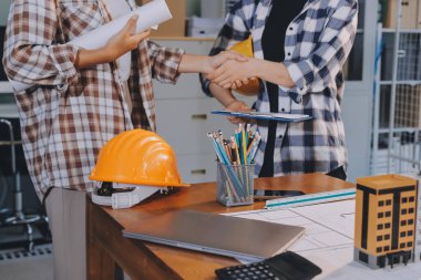 Modellik ve mühendislik araçları, inşaat konsepti ve çalışma sahasındaki proje ortağı ile çalışma planı toplantısı üzerine çalışan mühendis inşaat ve yapı kavramı.