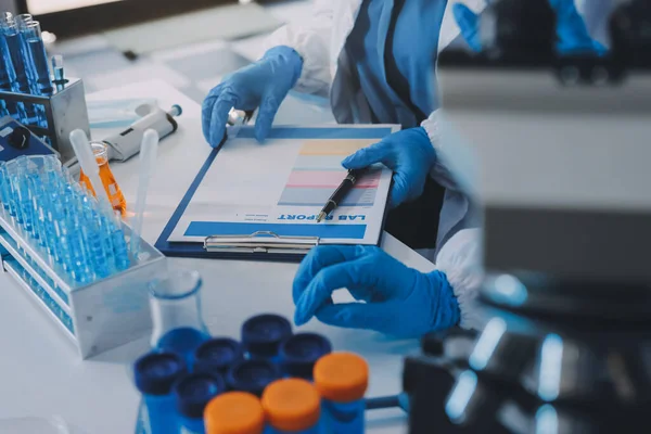 Araştırma ya da geliştirme için laboratuardaki insanlarla işbirliği, tablet ya da bilim. Tıbbi araştırma ve planlama için klinik deneyde bilim adamlarıyla buluşlar, teknolojiler ve mikroskop