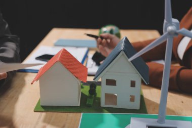 Ekip toplantısında, ESG konu sunumu için dizüstü bilgisayar kullanan Asyalı kadın, çok ırklı iş adamlarından oluşan genç bir gruba liderlik ediyor. Sürdürülebilir iş uygulaması, insanlar ev konseptinde çalışıyor